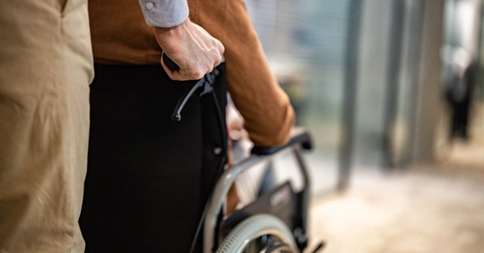 Pushing man in wheelchair